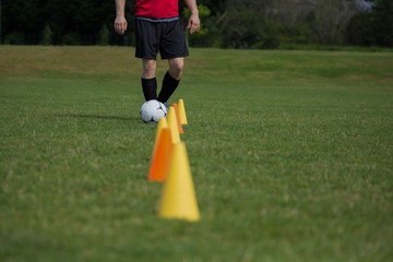 Wall Mural - Soccer player dribbling through cones