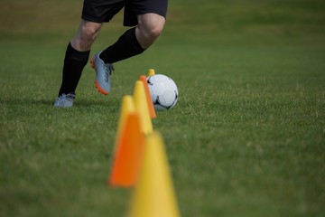 Wall Mural - Soccer player dribbling through cones