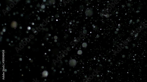 Fotografía Snowfall Bokeh Lights on Black Background, Shot of Flying Snowflakes in the Air