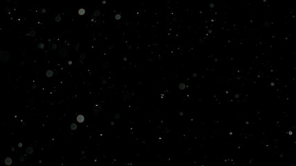 Wall Mural - snowfall bokeh lights on black background, shot of flying snowflakes in the air