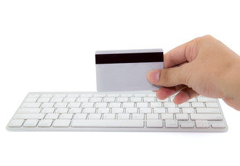 Macro close up of male hand holding credit card on keyboard.