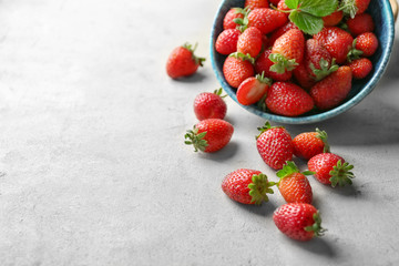 Sticker - Fresh ripe strawberries scattered from bowl on table