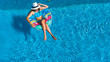 © Iuliia Sokolovska - Aerial top view of beautiful girl in swimming pool from above, relax swim on inflatable ring donut and has fun in water on family vacation