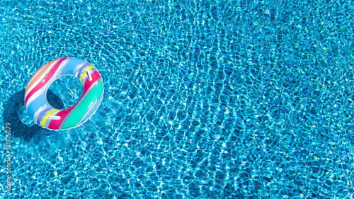 Obraz na płótnie Widok z lotu ptaka kolorowa nadmuchiwana ringowa pączek zabawka w pływackiej basen wodzie od above, rodzinnego wakacje pojęcia tło