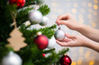 christmas background - close up of woman decorating christmas tree