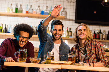 friends with pizza and beer in bar