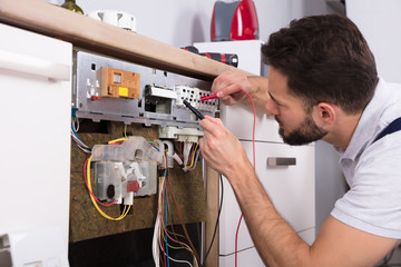 Male Technician Examining Dishwasher