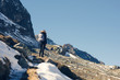 © flowertiare - A woman photographer with camera and backpack in a winter jacket with fur stands on the snow mountain in Switzerland.  Fluela pass in Switzerland in winter