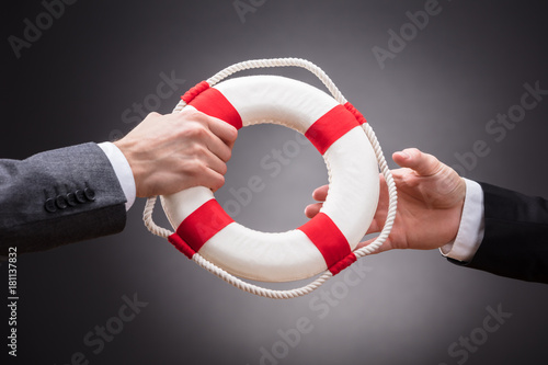 Fotomural Two Businesspeople Holding Lifebelt