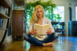 © PhotoAlto - Woman reading a book while sitting on floor