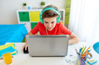 © Syda Productions - boy in headphones playing video game on laptop