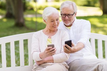 Sticker - happy senior couple with smartphones at park