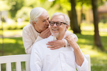 Canvas Print - happy senior couple sitting on bench at park