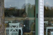 Young Woman Woking On Lunch Break In Cafe,. View Through The Window.