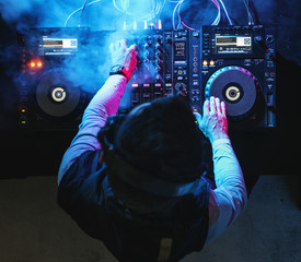 Wall Mural - Dj playing music at sound mixer in night club