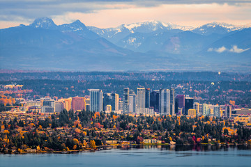 Fototapete - Bellevue Washington. The snowy Alpine Lakes Wilderness mountain peaks rise behind the urban skyline.