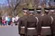 Łotwa, Ryga, oficjalna ceremonia z udziałem łotewskiej armii, święto narodowe Łotwy, grupa żołnierzy, tyłem, na drugim planie niewyraźna grupa ludzi uczestnicząca w święcie, park
