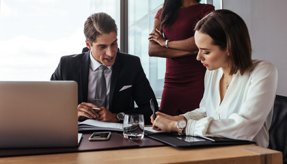 Boss dictating to assistant at office