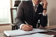 © Jacob Lund - Entrepreneur writing notes and talking on phone