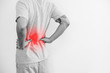 a man touching his back, with red highlight. Back pain, backache and waist pain, on white background with copy space