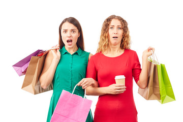 Portrait of two female friends holding multi-colored shopping bags