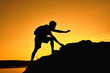 © sawitreelyaon - Silhouette of man hiking to the top mountain at sky sunset