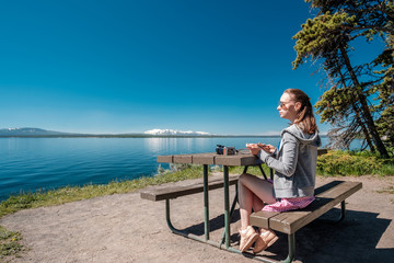 Wall Mural - Woman tourist having a breakfast by Yellowstone Lake