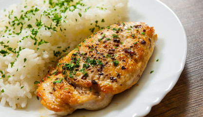 Wall Mural - fried chicken breast with rice on a wooden background.