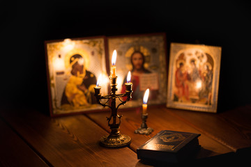 Wall Mural - burning candle in a dark room, orthodox