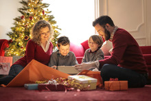 Sweet Family Looking At Christmas Gifts All Together