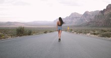 Woman Walking On Middle Of Street In Desert