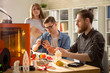 © Seventyfour - Group of young engineers carrying out quality inspection of prototype made with help of 3D printer while working together at modern laboratory