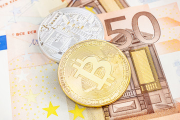 Two bitcoin coins on euro background. Business concept.