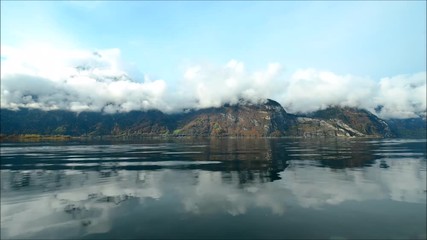 Canvas Print - Mountain landscape. The clouds are reflected in the lake. TimeLapse. After the ship ripples on the lake.