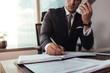 © Jacob Lund - Businessman talking on mobile phone and making notes