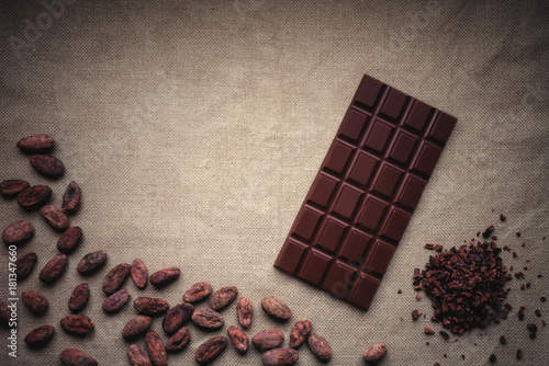 Zdjęcie XXL Ciemna czekolada i surowe ziarna kakaowe. Tło tekstura stary jutowy