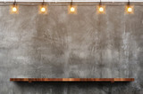 Empty brown wood plank board shelf at grunge concrete wall with light bulb string party background,Mock up for display or montage of product or design