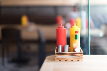 A Cafe Or Restaurant Tabletop Setup With Ketchup And Mustared Bottles And A Salt And Pepper Shakers