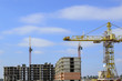 © uhfybn - Three construction cranes in the construction site.