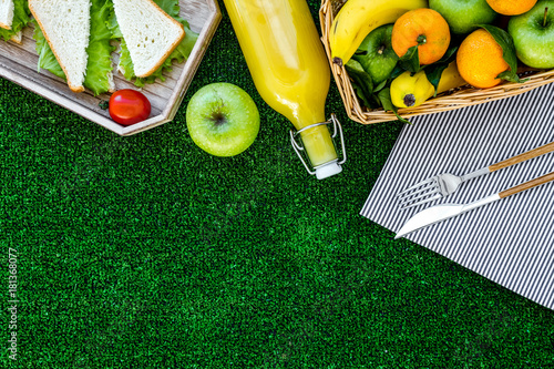 Plakat Zdrowa żywność na piknik. Sanwiches, owoc, warzywa, sok na tablecloth na zielonej trawy tła odgórnego widoku copyspace