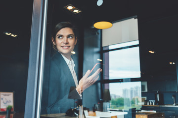 Wall Mural - Business concept, smart casual dressed woman with mobile phone standing in open space office. Succesful meeting debreifing