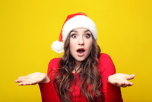 Young Woman In Santa Hat On Yellow Background