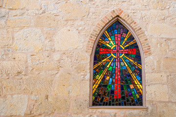 Gothic style church window with stained glass/ red cross made of stained glass