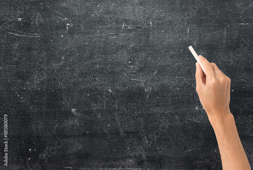 hand holding white chalk and starting to write on blank chalkboard
