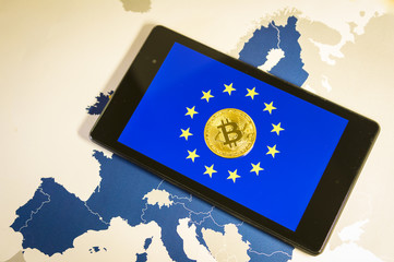 Financial concept with golden Bitcoin over smartphone, EU flag and map.