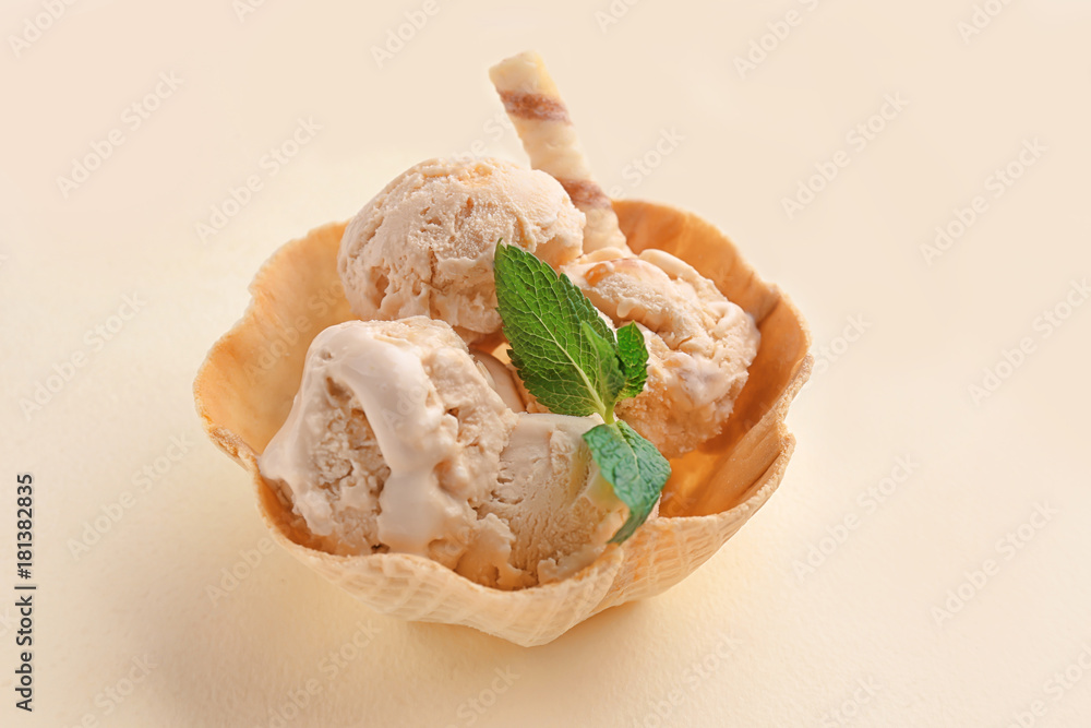 Waffle bowl with caramel ice cream on light background