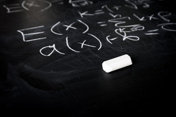 Part of maths formulas written by white chalk on the blackboard background.