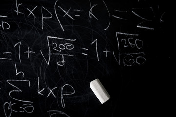 Part of maths formulas written by white chalk on the blackboard background.