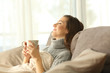 Woman relaxing at home holding a coffee mug