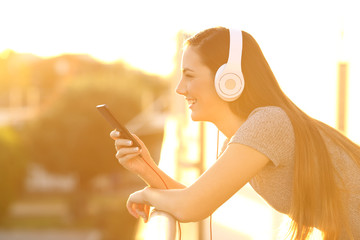 Sticker - Profile of a happy girl listening music in a balcony